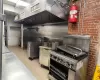 Kitchen with light tile patterned floors, stainless steel counters, and brick wall