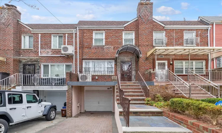 View of property with ac unit and a garage