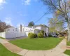 View of side of property with a yard and a garage