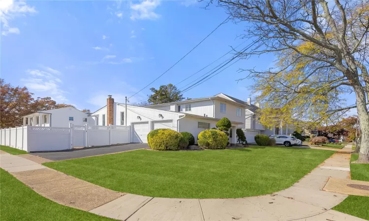 View of side of property with a yard and a garage