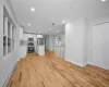 Unfurnished living room with a baseboard radiator, light hardwood / wood-style flooring, and sink