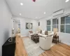 Living room featuring an AC wall unit and light hardwood / wood-style floors