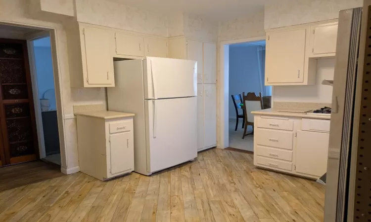 Kitchen featuring light hardwood / wood-style floors and white appliances