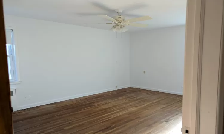 Unfurnished room featuring dark hardwood / wood-style floors and ceiling fan