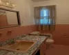 Bathroom featuring vanity, tile walls, and toilet