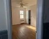 Spare room featuring ceiling fan, radiator heating unit, and wood-type flooring