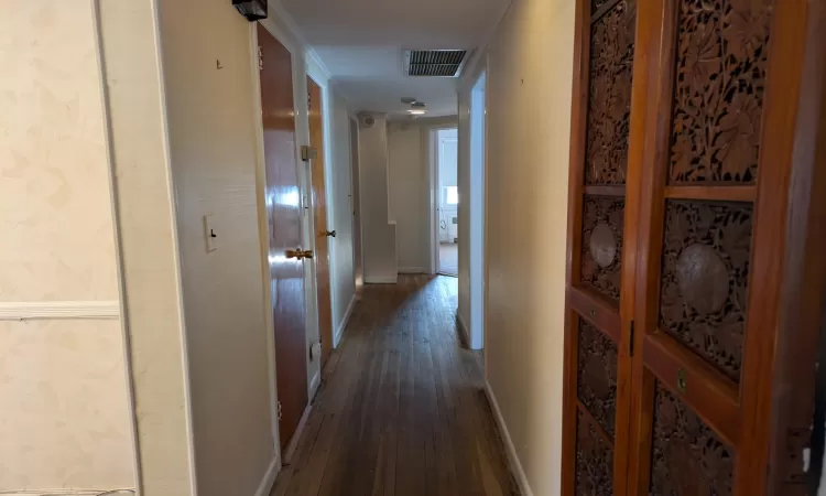 Hallway with dark hardwood / wood-style floors