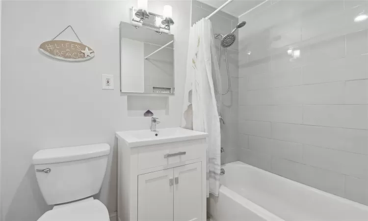 Full bathroom featuring shower / bath combo, vanity, and toilet