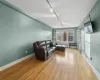 Living room with radiator heating unit, rail lighting, and light hardwood / wood-style flooring