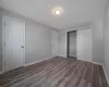 Unfurnished bedroom featuring dark wood-type flooring