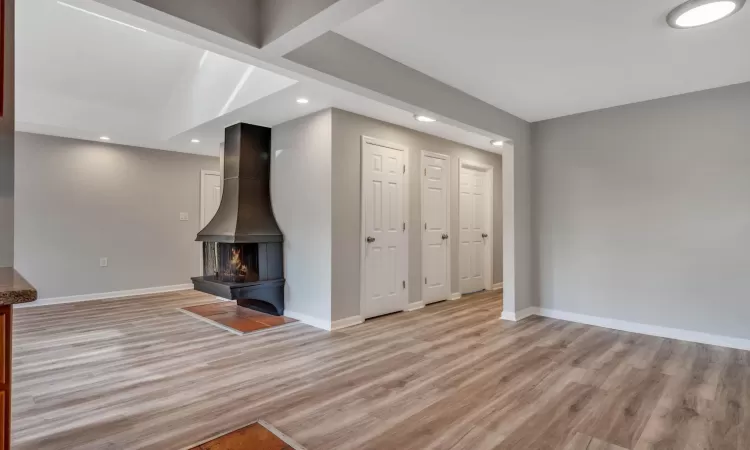 Unfurnished living room featuring light wood-type flooring and a wood stove