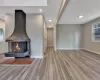 Unfurnished living room with a multi sided fireplace and light hardwood / wood-style floors