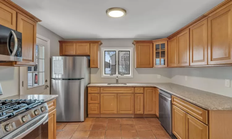 Kitchen with sink, light tile patterned flooring, and appliances with stainless steel finishes