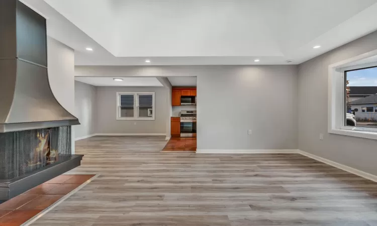 Unfurnished living room featuring a multi sided fireplace and light hardwood / wood-style flooring