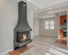 Unfurnished living room featuring a multi sided fireplace and light hardwood / wood-style flooring