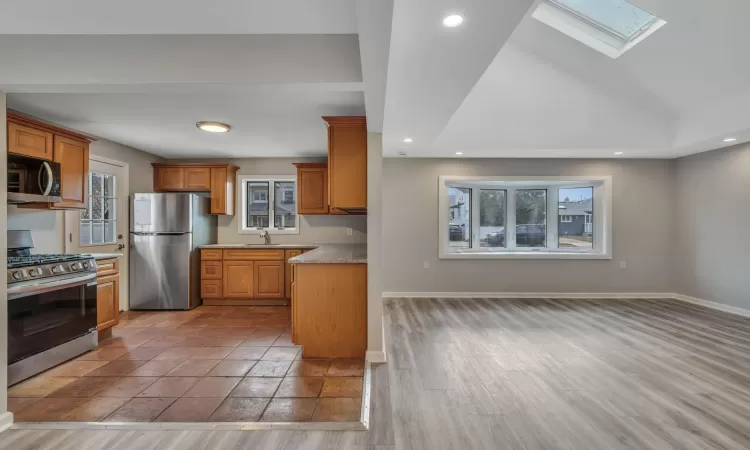 Kitchen featuring a healthy amount of sunlight, sink, appliances with stainless steel finishes, and light hardwood / wood-style flooring