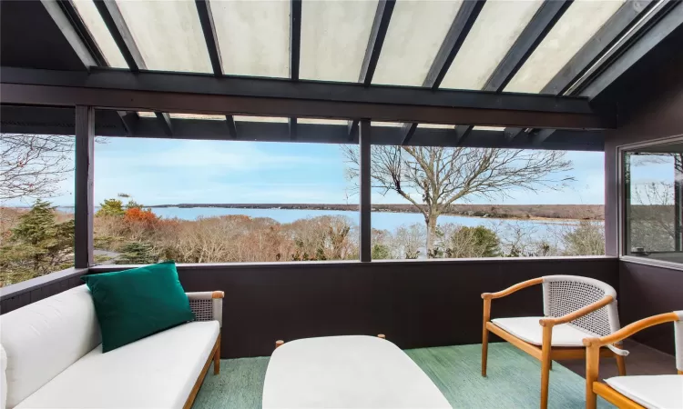 Sunroom / solarium with a water view and a healthy amount of sunlight