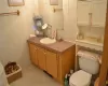 Bathroom featuring vanity and toilet and chandelier