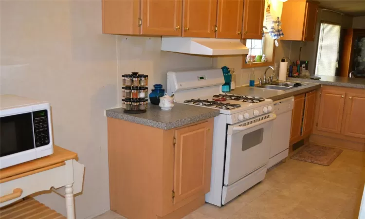 Kitchen with white appliances and sink