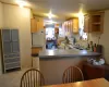 Kitchen with kitchen peninsula, sink, a healthy amount of sunlight, and white appliances