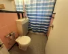 Bathroom featuring toilet and tile walls