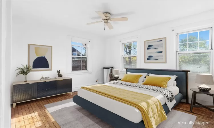 Bedroom featuring ceiling fan, dark wood-type flooring, and multiple windows