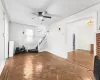 Unfurnished living room featuring ceiling fan and dark parquet flooring