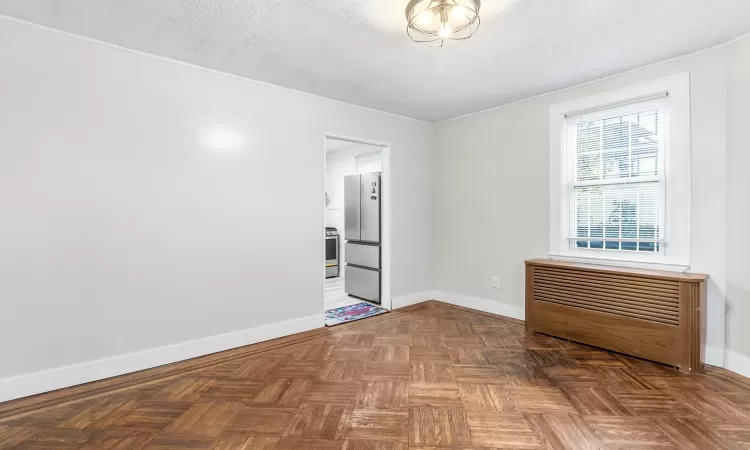 Spare room featuring parquet flooring and a textured ceiling