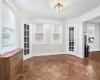 Spare room featuring french doors, dark parquet flooring, plenty of natural light, and a textured ceiling