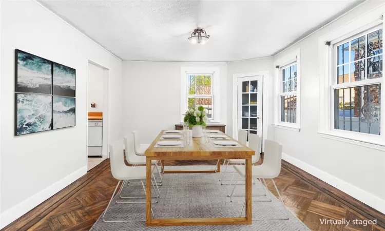 Dining space with dark parquet floors and a textured ceiling