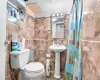 Bathroom with backsplash, curtained shower, toilet, and tile walls