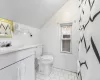 Full bathroom featuring tile patterned floors, lofted ceiling, vanity, and tile walls