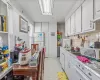 Kitchen with sink, tasteful backsplash, range hood, white appliances, and white cabinets