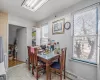 Dining area featuring baseboard heating, a wealth of natural light, and tile walls