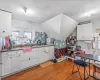 Kitchen featuring white cabinets, sink, vaulted ceiling, a textured ceiling, and light hardwood / wood-style floors