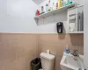 Bathroom featuring toilet, tile walls, and sink