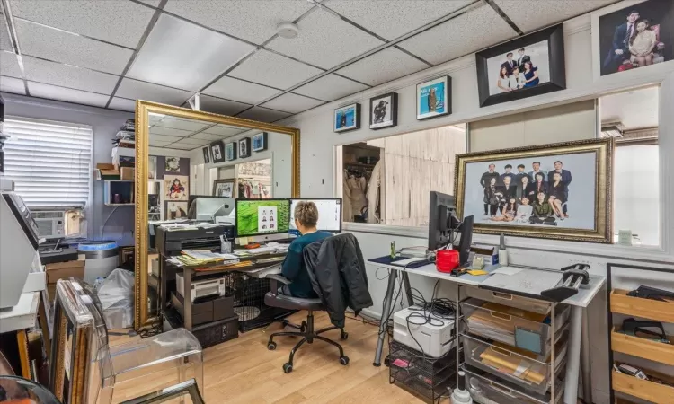 Office featuring wood-type flooring, a paneled ceiling, and cooling unit