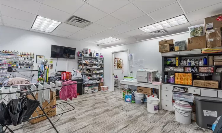 Office area featuring a drop ceiling and light hardwood / wood-style floors