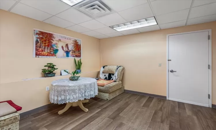 Living area with hardwood / wood-style floors and a drop ceiling