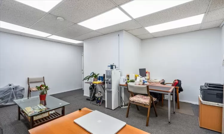 Home office featuring a drop ceiling and dark carpet