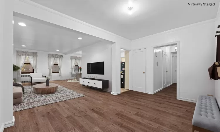 Living room featuring ornamental molding and hardwood / wood-style flooring