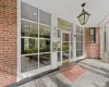 Doorway to property featuring covered porch