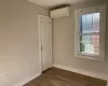 Spare room featuring an AC wall unit, crown molding, and dark hardwood / wood-style flooring