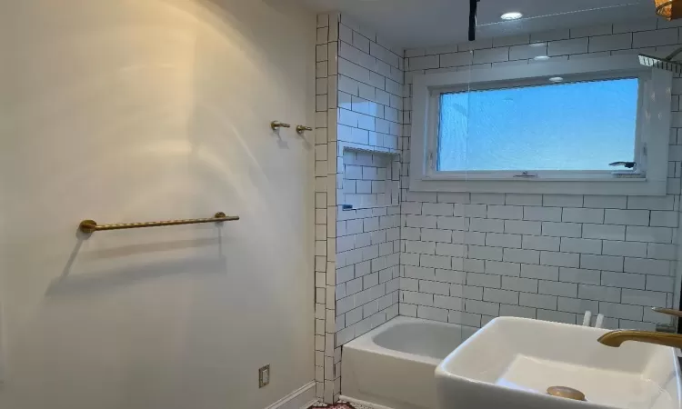 Bathroom featuring tiled shower / bath combo and sink