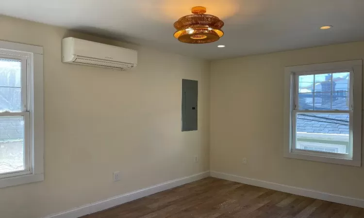 bed room featuring dark hardwood / wood-style flooring,  and an split unit