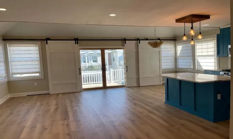 Kitchen featuring a barn door, decorative light fixtures, and plenty of natural light