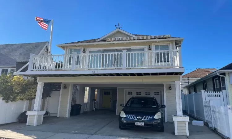 View of front of property featuring a carport and a balcony