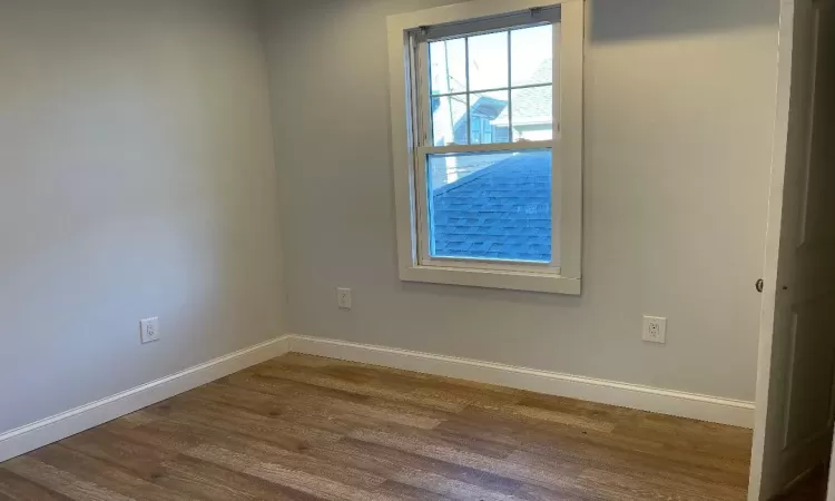 Empty room with hardwood / wood-style flooring