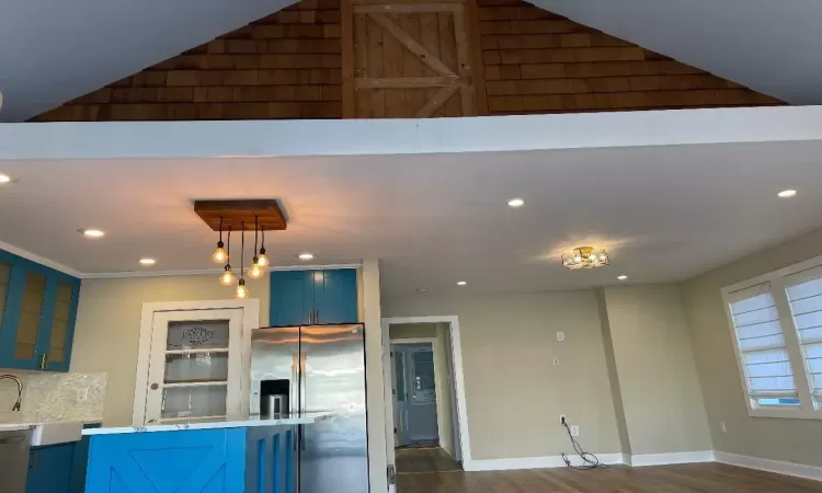 Kitchen with high vaulted ceiling, decorative light fixtures and blue cabinets