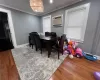 Dining area featuring an AC wall unit, hardwood / wood-style floors, a chandelier, and ornamental molding